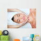 Beautiful young woman receiving facial massage. Wall Mural