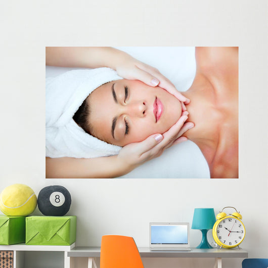 Beautiful young woman receiving facial massage. Wall Mural