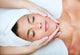 Beautiful young woman receiving facial massage. Wall Mural