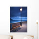 A Bench And Light Post Along The Railing On The Coast Wall Mural