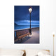 A Bench And Light Post Along The Railing On The Coast Wall Mural