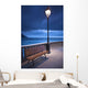 A Bench And Light Post Along The Railing On The Coast Wall Mural