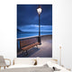 A Bench And Light Post Along The Railing On The Coast Wall Mural