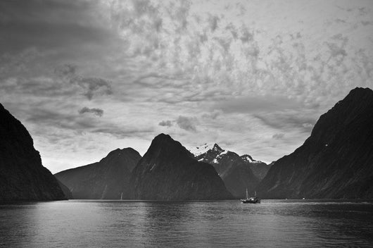 A Boat In The Water Along The Coast Surrounded By Mountains Wall Mural