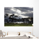 Sunlight Shining Through The Dark Clouds With Trees On The Shoreline Wall Mural