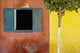 A Tree Outside A Colorful Building And A Window With Blue Shutters Wall Mural