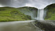 A Waterfall Over A Grassy Cliff Wall Mural
