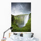 A Waterfall Over A Grassy Cliff Wall Mural