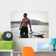 A Man Standing In The Water With His Surfboard Off Valdevaqueros Beach Wall Mural