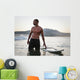 A Man Standing In The Water With His Surfboard Off Valdevaqueros Beach Wall Mural