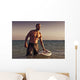 A Man With His Surfboard In The Water At Sunset Wall Mural