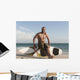 A Man Sits On His Surfboard On The Beach Wall Mural