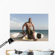 A Man Sits On His Surfboard On The Beach Wall Mural