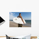 A Man Standing On The Beach Holding His Surfboard Wall Mural