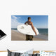 A Man Standing On The Beach Holding His Surfboard Wall Mural