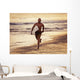 A Man Runs On The Wet Beach At Sunset With His Surfboard Wall Mural