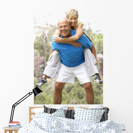 Senior Couple Exercising In Park Wall Mural