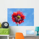 A Colorful Flower With Red And Purple Petals Against A Blue Sky Wall Mural