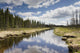 Clouds Reflected In A Tranquil River Lined With Trees Wall Mural