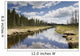 Clouds Reflected In A Tranquil River Lined With Trees Wall Mural