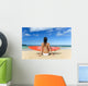 Hawaii, Kauai, Woman Sitting On Beach With Surfboard, View From Behind Wall Mural