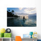 Woman Paddling In Outrigger Canoe Along Shoreline Wall Mural