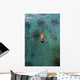 School Of Fish Encircling Woman Floating In Tropical Ocean Water Wall Mural
