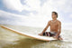 Hawaii, Oahu, Young Man Sitting On His Surfboard At The Shoreline Wall Mural