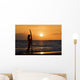Female Surfer On Beach Silhouetted Against Orange Sunset Over Ocean Wall Mural