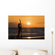 Female Surfer On Beach Silhouetted Against Orange Sunset Over Ocean Wall Mural