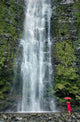 Woman Stands With Umbrella At The Base Of Waterfall Wall Mural