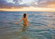 Hawaii, Kauai, Woman Walking In The Ocean As The Sun Sets Wall Mural