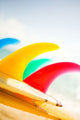 Colorful Surfboards Fins, Bright Sunny Sky In Background Wall Mural
