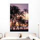 Palm trees and a couple in beach chairs at sunset at Anaehoomalu Bay Wall Mural