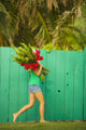 Woman holding red and pink ginger flowers Wall Mural