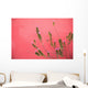 A Pink Flowering Plant Growing Beside A Red Wall Wall Mural