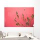A Pink Flowering Plant Growing Beside A Red Wall Wall Mural