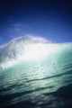 Closeup angle of green wave with backlit crest, bright blue sky Wall Mural