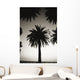Silhouetted palm tree centered between other palm tree tops at dusk Wall Mural