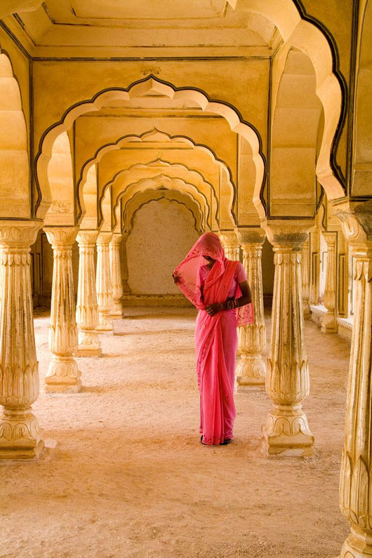 Woman In Bright Pink Sari Stands Beneath Arches Wall Mural