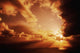 Orange Sunset Over Ocean, Sunrays Bursting Through Puffy Clouds Wall Mural