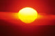 Gorgeous Sun Setting In Bright Orange Sky Over Ocean Wall Mural