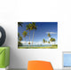 Grassy shoreline with tall palm trees Wall Mural