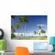 Grassy shoreline with tall palm trees Wall Mural
