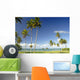 Grassy shoreline with tall palm trees Wall Mural