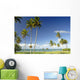 Grassy shoreline with tall palm trees Wall Mural