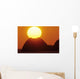Sun Setting In Orange Sky Over Ocean And Silhouetted Hill Wall Mural