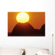Sun Setting In Orange Sky Over Ocean And Silhouetted Hill Wall Mural