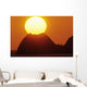 Sun Setting In Orange Sky Over Ocean And Silhouetted Hill Wall Mural