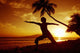 Woman Doing Yoga By The Ocean At Sunset Under Palm Tree Wall Mural